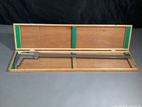 Open wooden box with the 24-inch stainless steel Kanon vernier caliper inside, showing the overall length and box interior.