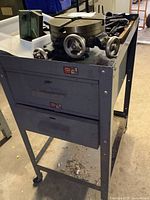 Wide view of gray steel cabinet with two drawers and Palmgren turret head on top