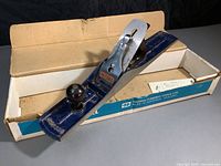 Full view of the Record Ridgway No.7 jointer bench plane placed inside its original cardboard box with visible brand markings and papers.