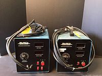 Two RoMan Impedance Master IM-9I devices side by side showing front panels with control dials, digital readouts, and test leads.