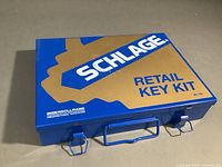 Blue metal Schlage retail key kit box closed, showing brand and model.