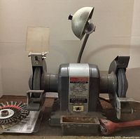 Front view of Sears Craftsman bench grinder with lamp, tool rests, and two grinding wheels assembled