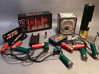 Full lot with all eight shooter-themed items including boxed shot glasses, kaleidoscope, pen, flashlight, and light strand