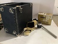 Overview showing black storage case, beige canvas bag, Nikon lens and bellows focusing attachment