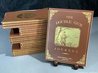Stack of 20 issues of The Double Gun Journal quarterly magazines from volumes 13 to 17 with brown covers and gold embossed titles
