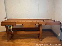 Full front view showing entire bench with both vices and row of dog holes