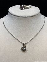 Chain and ring displayed on a bust showing overall appearance of both items