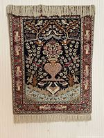 Full view of vintage prayer rug with floral and bird motifs, fringed edges visible at top and bottom