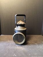 Front view of vintage railway signal lamp with large circular lens and metal handle.