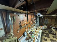 Wide view of plywood pegboard with hanging tools and workbench surface