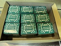 Top view showing 9 green original boxes all with the 'Cornwall Cottage Collection' logo and decorative ivy design.