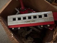 Box containing Lionel Lines silver and red passenger train car with visible windows and wheels.