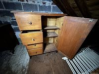 Vintage wooden child’s dresser with drawers partly open and side cabinet open, showing interior shelves.