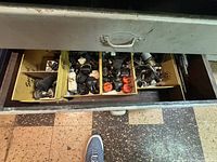 Top view of one metal drawer showing boxes with various electrical fittings, sockets, and small hardware items.