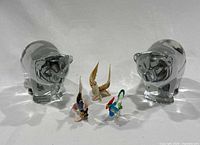 Wide view of two clear glass bears and three smaller colorful glass animal figurines (chicken, bird, fish) on a white background.