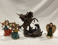 Front view of St. George on horse fighting dragon with three painted resin angels in front