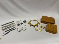 Photo showing all items in the lot including bracelets, pendants, keychains, necklace set, earrings, and leather boxes
