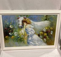 Frontal view of the framed painting showing the girl and white horse in flower field with some reflections on the frame glass.