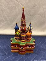 Front view showing colorful hand-painted onion domes and red base with decorative window shapes.