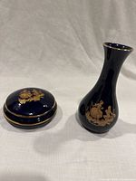Photo of dark blue cobalt porcelain vase and matching trinket box with 22K gold accents on a white background.