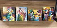 Full view of all four paintings side by side on a wood surface.