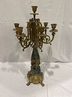 Front view of the candelabra showcasing the 7 candle holders, brass detailing, green marble central column, and ornate base with claw feet.