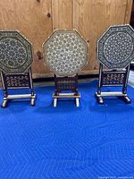 Three octagonal tables displayed together on blue protective blanket against wood backdrop