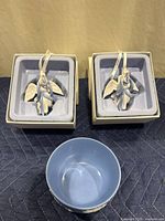 Two Wedgwood porcelain angel ornaments in white boxes with foam inserts and a blue Wedgwood bowl in front.