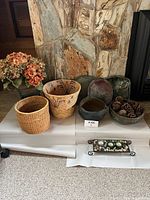 Photo showing the 10 pieces of vintage pottery and baskets arranged on a white cloth, including woven baskets, pottery bowls, trays, and candle holder tray.