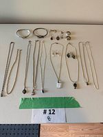 Overhead view of all 20 jewelry pieces arranged on white surface