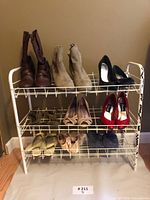 Front view showing all nine pairs of women's shoes on white metal shoe rack, including boots, heels, and flats.