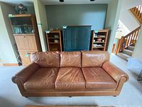 Front view of three-seat brown leather sofa in living room