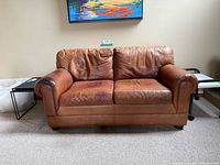 Front view of caramel brown leather loveseat