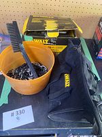 Photo showing orange bucket with metal chain and large brush along with DeWalt box and black zippered carrying case.