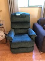 Front view of a green fabric Lazy Boy rocker recliner chair with plush padded arms and a segmented cushioned backrest.