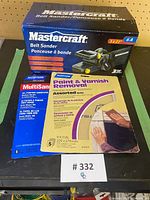 Photo of boxed Mastercraft belt sander alongside Norton sandpaper packs