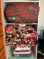 Shelf with full/queen duvet covers in paisley and floral patterns and folded linens below