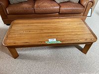 Front and side view of solid oak coffee table showing natural wood grain and thick square legs.