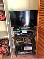 Full view of the TV, Blu-Ray player, tuner, and TV stand showing front perspective