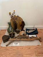 Full lot photograph showing the arrangement of all items on a cloth on wooden floor against a white wall.