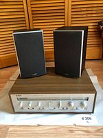 Front view of Yamaha CR-420 stereo receiver and Polk Audio speakers placed on a white surface with wooden louver background.