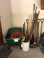 Overview of wheelbarrow, extension cords and assorted garden tools