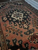 Close-up front view of Bakhtiari rug showing central medallion and floral geometric patterns in earth tones.