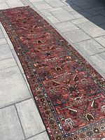 Full-length shot of red runner rug laid on stone patio