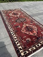 Full length angled view of the runner rug laid on grey stone floor showing geometric design and colors.
