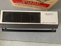 Front view of Sharp Model RT-5050 tape recorder showing overall form and original packaging box.