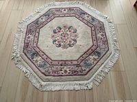 Top-down view of the octagonal rug showing floral medallion, border, and fringe details.
