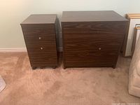 Two brown woodgrain filing cabinets side by side, one taller with two long drawers, one shorter with three drawers and wheels