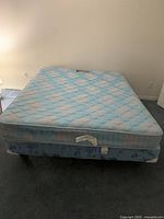 Queen size bed and mattress with visible mattress label showing Sears Pedic branding and floral pattern
