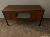 Front view of wooden desk showing six drawers and overall condition